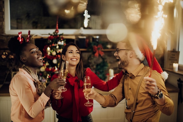 Grupo de amigos felices divirtiéndose mientras celebran el Año Nuevo juntos en casa