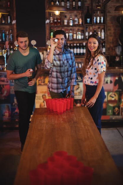 Grupo de amigos felices jugando juego de cerveza pong