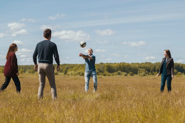 Grupo de amigos felices jugando voleibol en el campo de verano