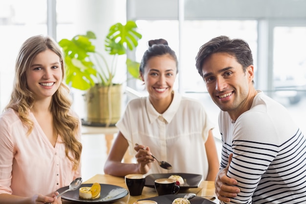 Grupo de amigos felices con postre juntos