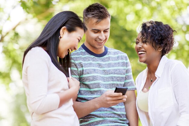 Foto grupo de amigos felices con teléfonos inteligentes al aire libre