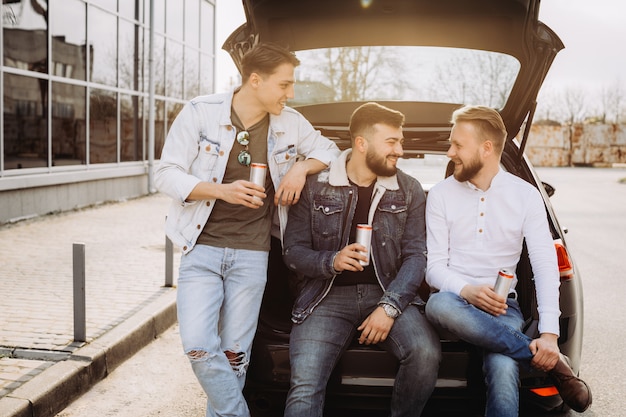 Un grupo de amigos hablando en el maletero del coche.