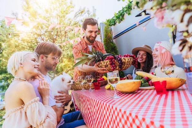 Un grupo de amigos hace un picnic con una caravana en un día caluroso