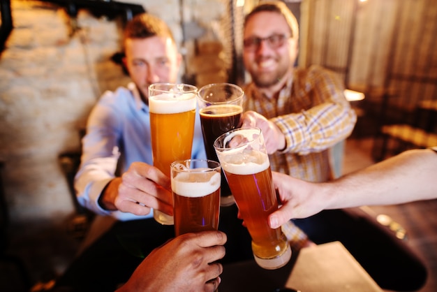 Grupo de amigos haciendo un brindis en pub.