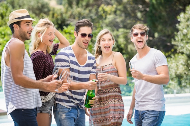 Grupo de amigos haciendo estallar una botella de champán