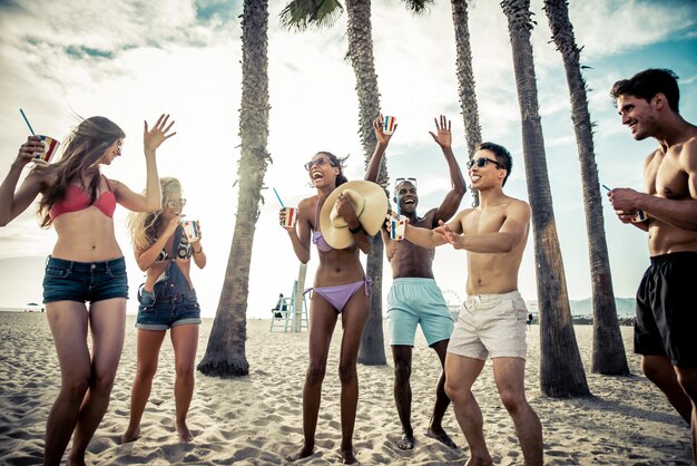 Grupo de amigos haciendo gran fiesta en la playa