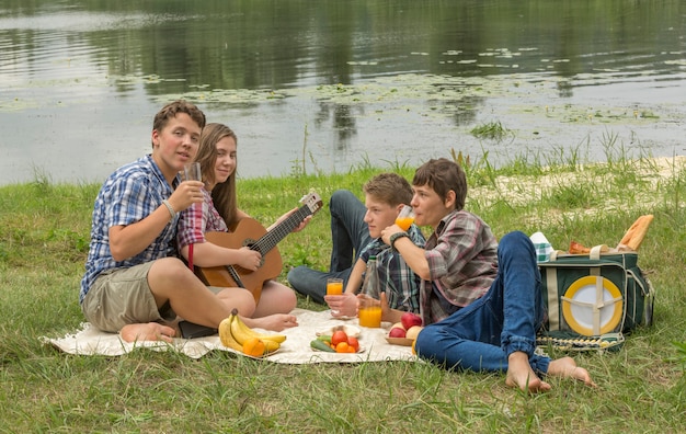 Foto grupo de amigos haciendo un picnic cerca del río