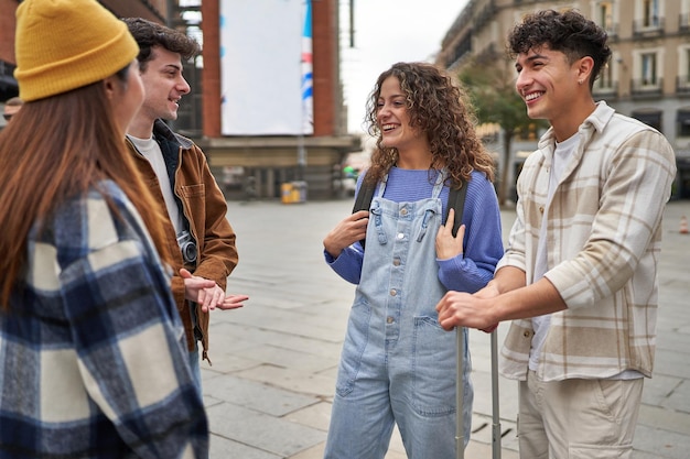 Un grupo de amigos ilusionados de diferentes culturas riéndose y disfrutando de su llegada a Madrid