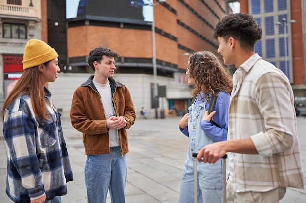 Un grupo de amigos ilusionados de diferentes culturas riéndose y disfrutando de su llegada a Madrid