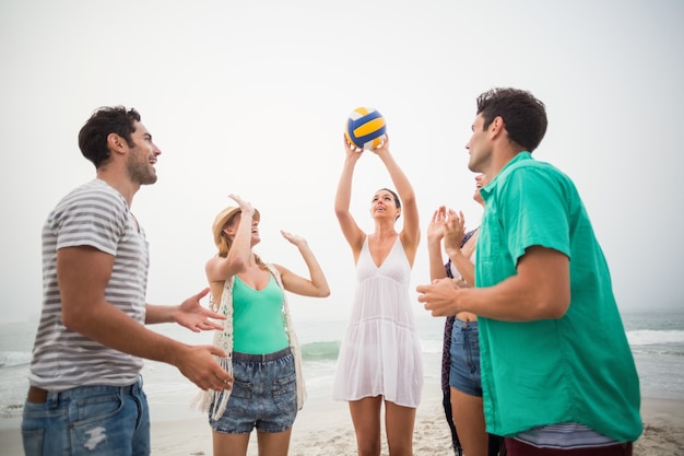 Grupo de amigos jugando con una pelota de playa