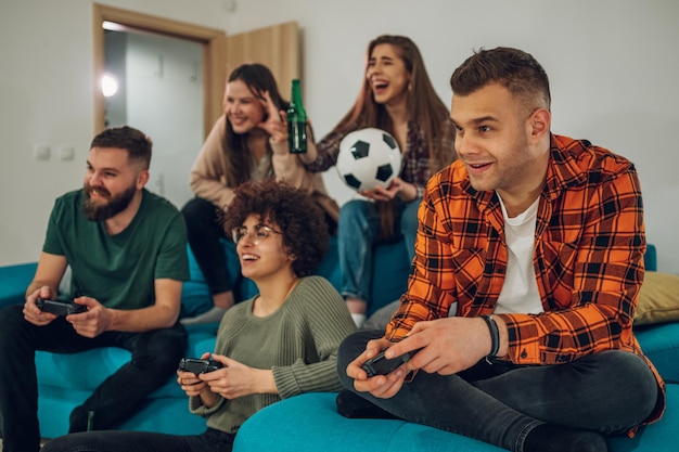 Grupo de amigos jugando videojuegos en casa