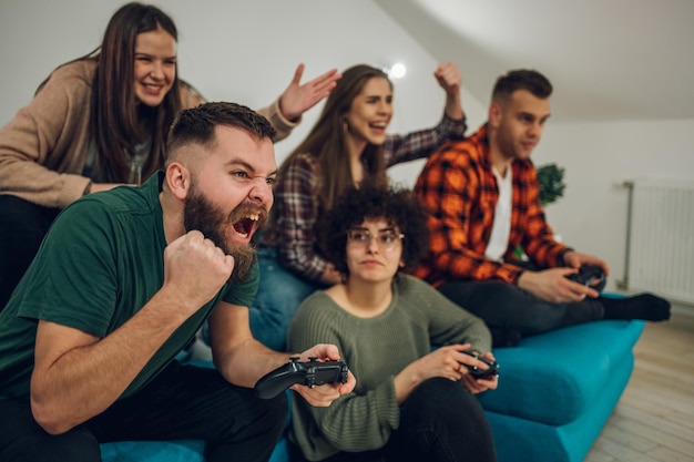 Grupo de amigos jugando videojuegos en casa
