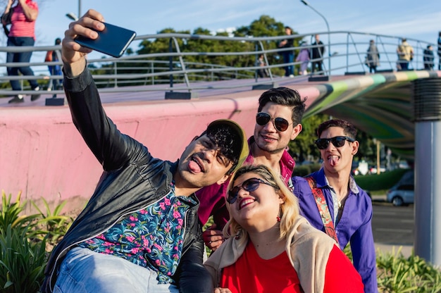 Grupo de amigos latinos al aire libre tomando un selfie