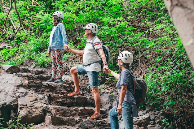 Grupo de amigos mayores excursionistas con mochilas disfrutando de un día de trekking en un estilo de vida saludable en la montaña