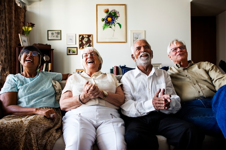 Foto grupo de amigos mayores sentados y viendo la televisión juntos