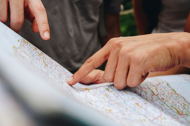 Grupo de amigos mirando un mapa juntos concepto de viaje y trabajo en equipo