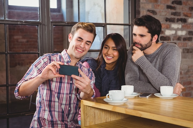 Foto grupo de amigos mirando un teléfono inteligente