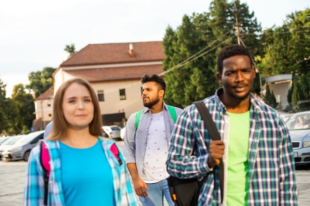 Grupo de amigos multiétnicos caminando por la ciudad