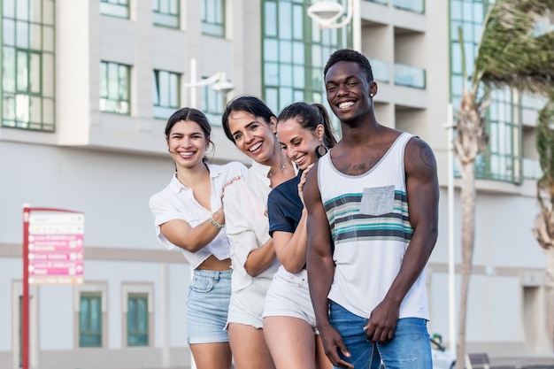 Grupo de amigos multiétnicos posando en la ciudad