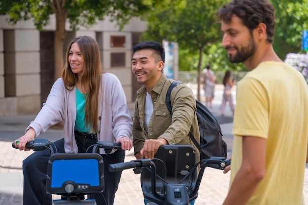 Grupo de amigos multiétnicos en la reunión de la ciudad a la hora de la reunión junto a bicicletas de alquiler