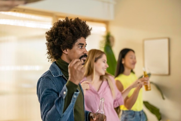 Grupo de amigos multirraciales celebran la fiesta en casa bailando y divirtiéndose enfocándose en el hombre africano