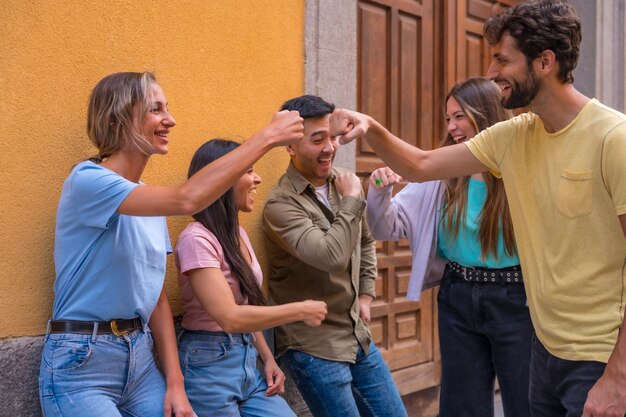 Grupo de amigos multirraciales saludando en el concepto de amistad de la ciudad con chicos y chicas