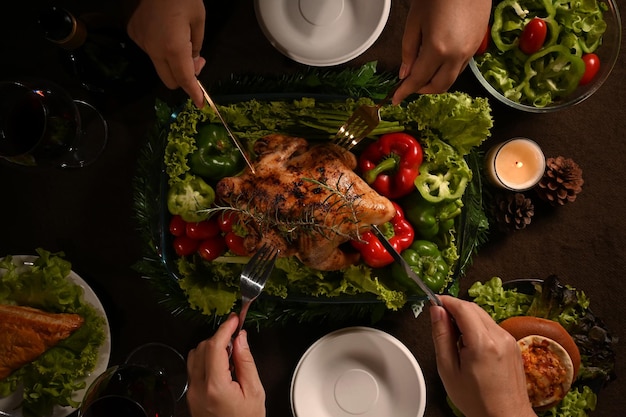 Grupo de amigos o familiares disfrutan comiendo pavo asado Comida de Acción de Gracias juntos Concepto de cena tradicional de celebración de Acción de Gracias