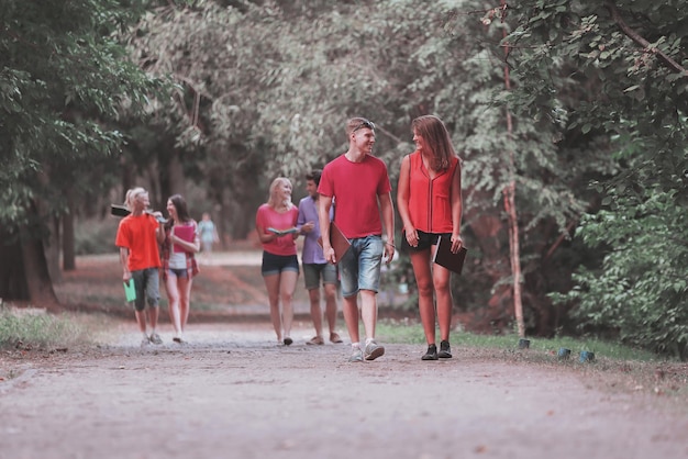 Grupo de amigos en el parque caminando y disfrutando del tiempo todos juntos