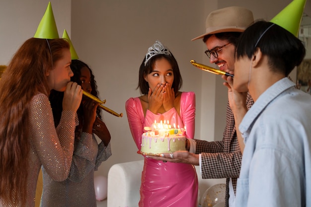 Grupo de amigos con pastel en una fiesta sorpresa de cumpleaños