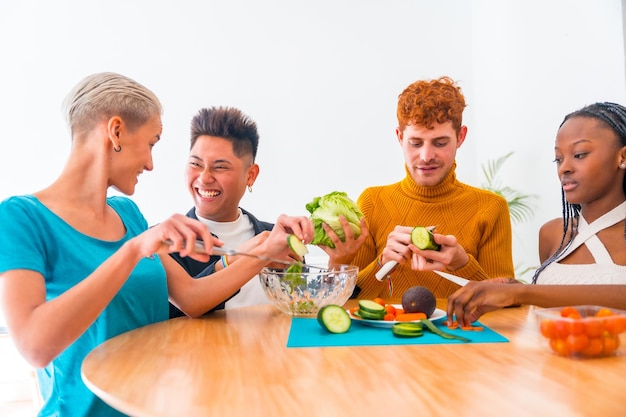 Grupo de amigos preparando una ensalada Preparan comida y se divierten en la cocina