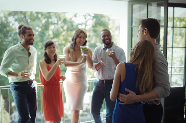 Foto grupo de amigos que interactúan entre sí mientras toman un cóctel