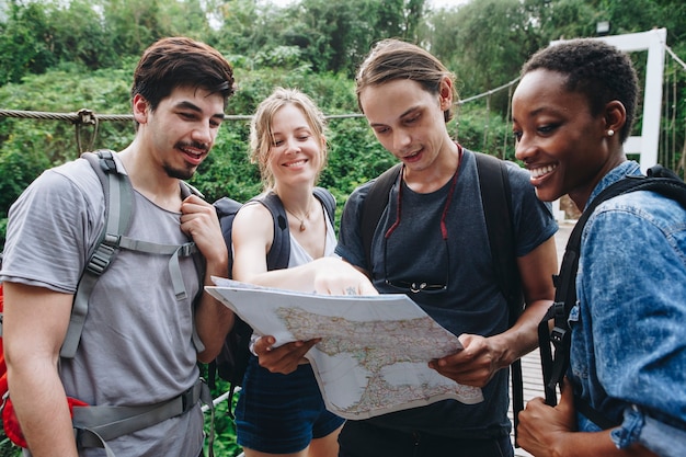 Grupo de amigos que miran un mapa juntos viaje y concepto de trabajo en equipo