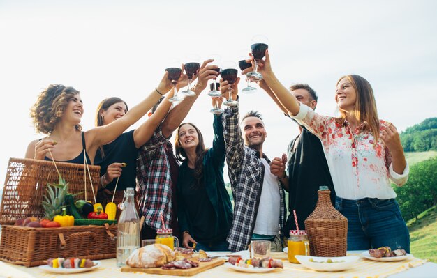 Grupo de amigos que pasan tiempo haciendo un picnic y una barbacoa