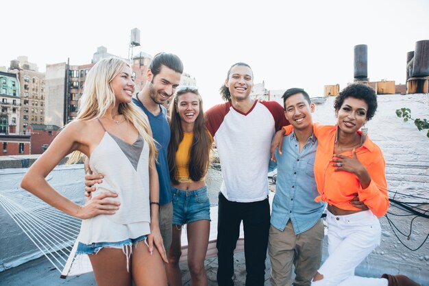 Grupo de amigos que pasan tiempo juntos en una azotea en la ciudad de Nueva York, concepto de estilo de vida con gente feliz