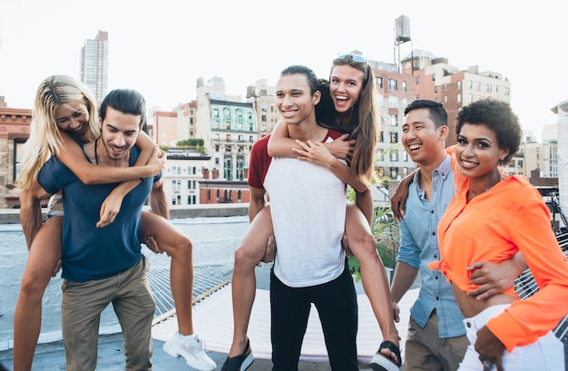 Grupo de amigos que pasan tiempo juntos en una azotea en la ciudad de Nueva York, concepto de estilo de vida con gente feliz