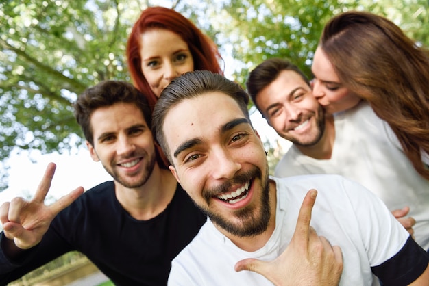 Grupo de amigos que toman selfie en fondo urbano