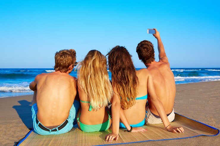 Foto grupo de amigos selfie foto sentado en la arena de la playa