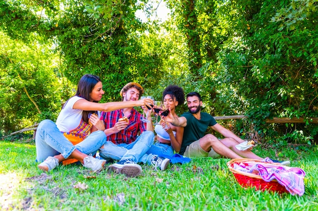 Foto grupo de amigos sentados en la hierba contra los árboles