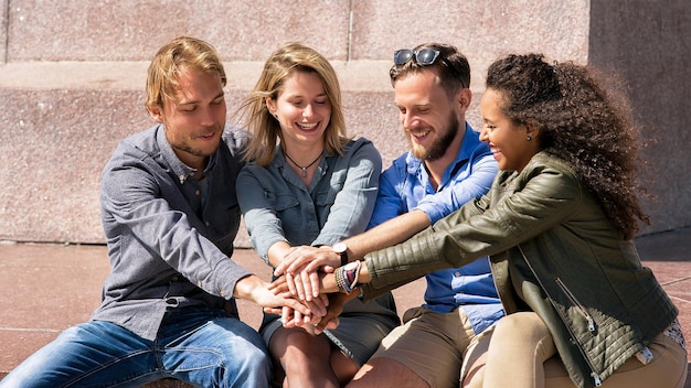 Grupo de amigos sonrientes se toman de la mano. Concepto de unión