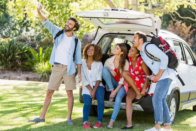 Foto grupo de amigos tomando una selfie desde la cajuela del automóvil