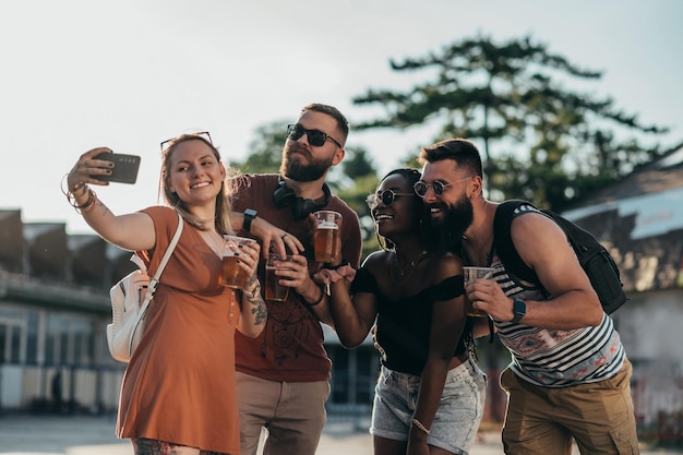 Grupo de amigos tomando selfie con un smartphone en un festival de música