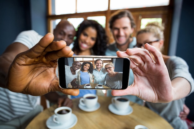 Foto grupo de amigos tomando una selfie desde teléfono móvil