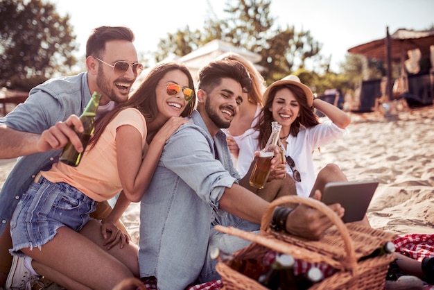 Grupo de amigos tomándose un selfie con tablet divirtiéndose