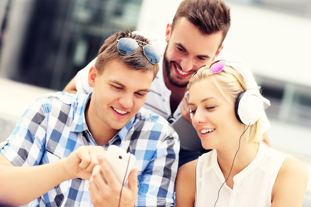 un grupo de amigos usando teléfonos inteligentes en el campus.