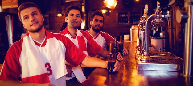 Grupo de amigos varones viendo el partido de fútbol