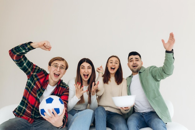 Grupo de amigos viendo fútbol en casa Amigos celebran emotivamente la victoria