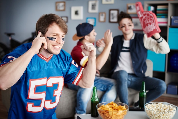 Grupo de amigos viendo fútbol en casa