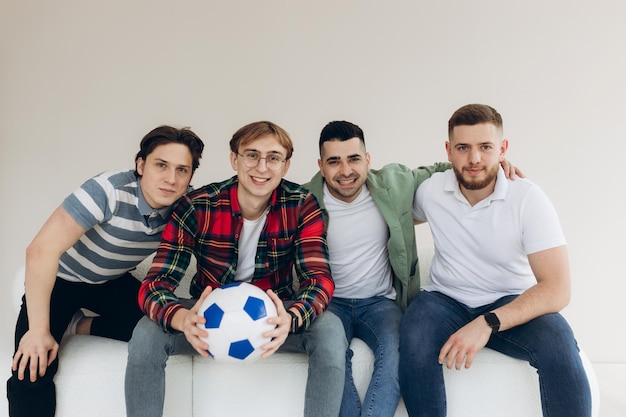 Un grupo de amigos viendo un partido de fútbol en la televisión