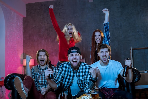 Foto grupo de amigos viendo la televisión en casa