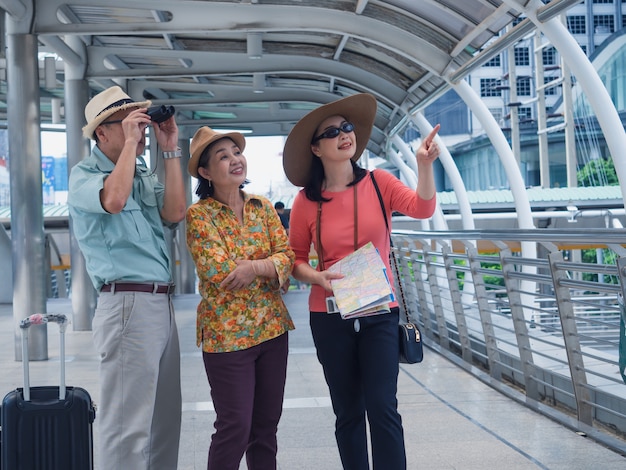 Grupo de ancianos caminando y hablando a pie en la ciudad, el anciano y la mujer viajan en vacaciones